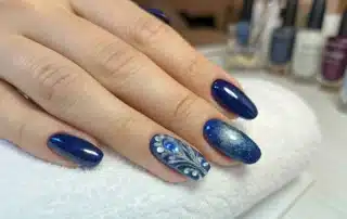 nail technician painting nails in professional salon